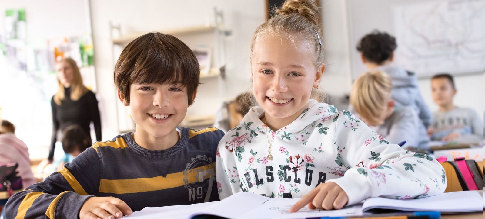 Ein Mädchen und ein Junge der 5. Klasse arbeiten gemeinsam an einer Aufgabe. 